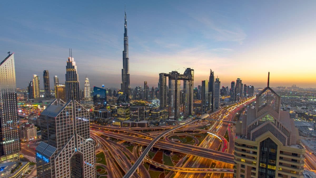 aerial view of Dubai as the sun sets rush hour traffic can be seen on the roads as the sky high buildings are clearly visible